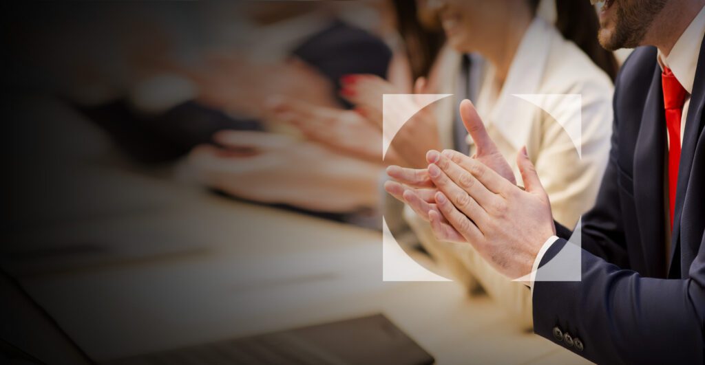 Profesionales aplaudiendo en reconocimiento a los premios y distinciones internacionales de LFS en consultoría tributaria y precios de transferencia.